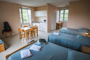 a living room with two beds and a kitchen at Accueil du Couvent de Malet in Saint-Côme-dʼOlt