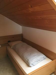 a bed in a room with a wooden ceiling at Fallerhof in Villnoss