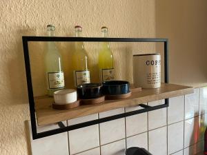 a shelf with bottles and candles on a wall at Hochwertige Wohnung im EG- Meißen zum Genießen in Meißen +14 photos
