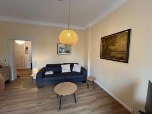 a living room with a blue couch and a table at Hochwertige Wohnung im EG- Meißen zum Genießen in Meißen