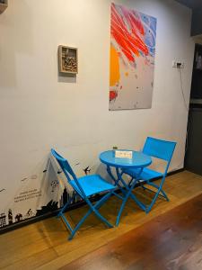 two blue chairs and a table in a room at Downtown Hotel in Tbilisi City
