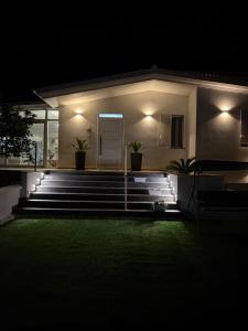 a house at night with a green lawn in front at Villa Amelia in Capaci