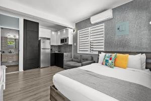 a bedroom with a large bed and a kitchen at La Balandra Luxury Stays in Dorado