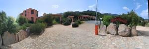 a rendering of a courtyard with a building and a church at Hotel La Corte Rosada in Villasimius