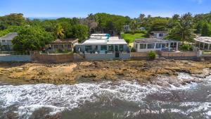 a house on the shore of a body of water at La Balandra Luxury Stays in Dorado