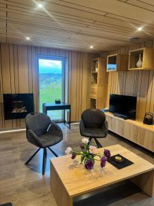 a living room with two chairs and a coffee table at ARD'n aise in Stoumont