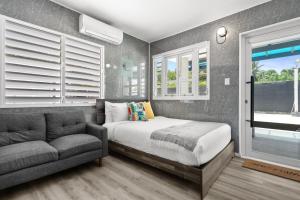 a bedroom with a bed and a couch and windows at La Balandra Luxury Stays in Dorado