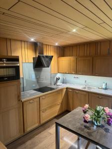 a large kitchen with wooden cabinets and a table at ARD'n aise in Stoumont +14 photos