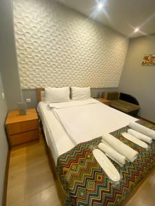 a bedroom with a bed with white sheets and pillows at Downtown Hotel in Tbilisi City