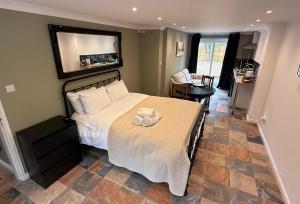 a bedroom with a bed with a towel on it at Modern Bicester Studio Self-Contained with Parking in Bicester