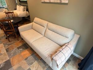 a white couch in a living room with a table at Modern Bicester Studio Self-Contained with Parking in Bicester
