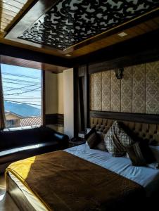 a bedroom with a large bed and a couch at Golden Glow Stays in Shimla +10 photos