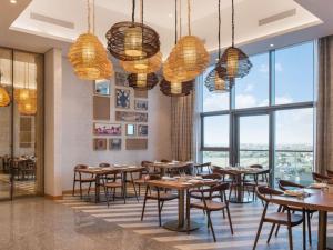 a restaurant with tables and chairs and large windows at 3br - PoolAccess - 7 MinstoDubai Mall - 2 KingBeds in Dubai