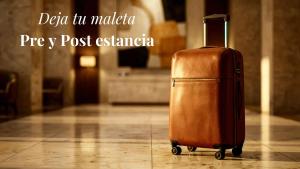 a brown suitcase is sitting on a tile floor at Edenia Hotel & Nature in El Calafate
