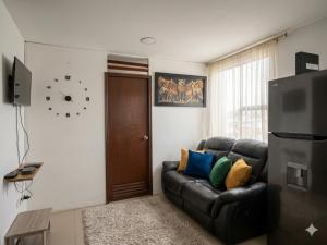 a living room with a couch and a clock on the wall at Apartaestudio amoblado Aeropuerto PIMSA bombona in Malambo