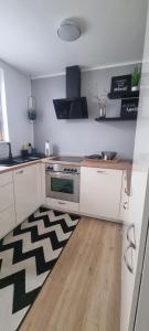 a kitchen with a stove and a rug on the floor at Wohlfühlen in Hohberg in Hohberg