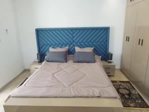 ein großes Bett mit blauem Kopfteil in einem Schlafzimmer in der Unterkunft Djerba Aldo Piscine in Houmt Souk + 49 Fotos