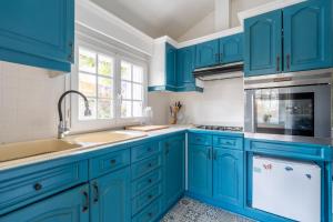 a kitchen with blue cabinets and a sink at Maison semi-troglo - Proche Chenonceaux - Amboise - La Caburoche de Charlemagne in Civray-de-Touraine