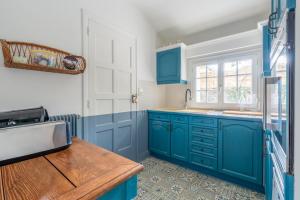 a kitchen with blue cabinets and a sink at Maison semi-troglo - Proche Chenonceaux - Amboise - La Caburoche de Charlemagne in Civray-de-Touraine +39 photos
