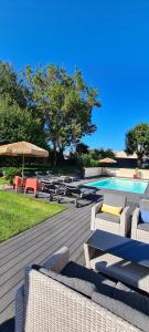 a group of chairs and umbrellas next to a swimming pool at La Fompatoise in Vérines