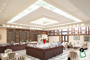 a dining room with tables and chairs and a skylight at Hotiday Brindisi Garibaldi in Brindisi