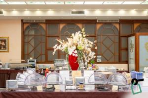 a room with a table with a vase of flowers at Hotiday Brindisi Garibaldi in Brindisi