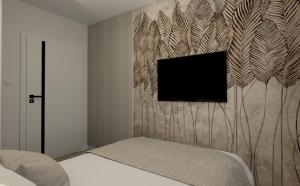 a bedroom with a tv on a wall at Classic&Modern Suite in Kętrzyn