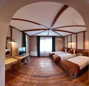 a hotel room with three beds and a television at Diamond Koru Hotel in Amasra +44 photos