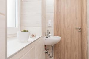 a bathroom with a sink and a wooden door at Randevú Panzió in Sopron +33 photos