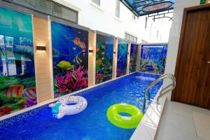 a swimming pool with an aquarium painted on the wall at Amelia Sầm Sơn Boutique Holtel in Sầm Sơn