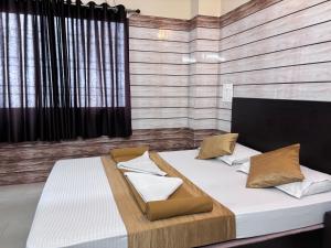 two beds in a bedroom with a wooden wall at Hotel Yamunna Boarding and Lodgeing in Kollūru