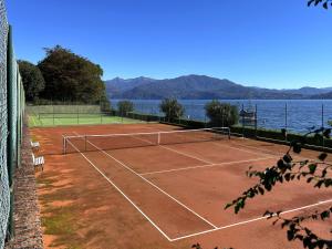 a tennis court next to a body of water at Appartamento Pascià al Lago in Oggebio