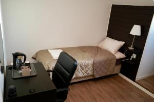 a bedroom with a bed and a desk with a desk at Järnvägshotellet Charlottenberg in Charlottenberg