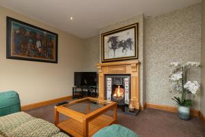 a living room with a fireplace and a couch at Copperbeech Farm Guest House in Moira