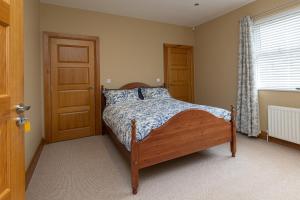 a bedroom with a bed and a wooden door at Copperbeech Farm Guest House in Moira