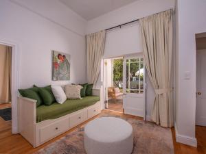 a living room with a green couch and a window at House Erens By Die Bos in Stellenbosch