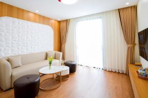 a living room with a couch and a table at Amelia Sầm Sơn Boutique Holtel in Sầm Sơn