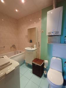 a bathroom with a toilet and a sink and a tub at MERE Apartment in Sillamäe