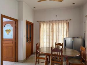 a dining room with a table and a refrigerator at Serenity Villa in Mysore +7 photos