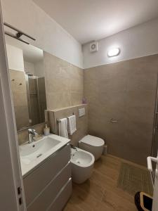 a bathroom with a sink and a toilet and a mirror at La casa di Giorè - Fronte Mare Gabbiani Ombrellone e 2 lettini inclusi in Fano