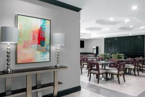 a dining room with tables and chairs and a painting on the wall at Best Western Plus Miami-Doral/Dolphin Mall in Miami