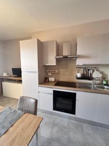 a kitchen with white cabinets and a sink and a table at La casa di Giorè - Fronte Mare Gabbiani Ombrellone e 2 lettini inclusi in Fano +31 photos