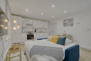 a white kitchen with a blue bed in a room at The Cozy Quarter in Bromley