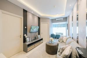 a living room with a couch and a tv at Amalea at Benson Pakuwon Mall in Surabaya