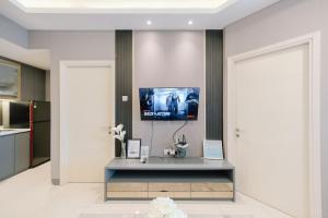a living room with a tv on a wall at Amalea at Benson Pakuwon Mall in Surabaya