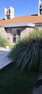 a house with some tall grass in front of it at House Urban in Merlo