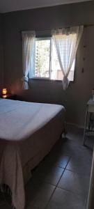 a bedroom with a bed and a window at House Urban in Merlo