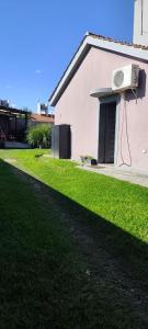a house with an air conditioner on the side of a yard at House Urban in Merlo