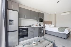 a bedroom with a bed and a kitchen with a microwave at Vista Zimbali in Ballito