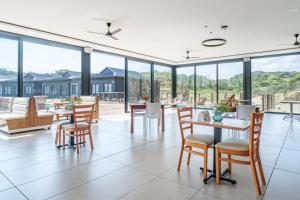 a large room with tables and chairs and glass windows at Vista Zimbali in Ballito